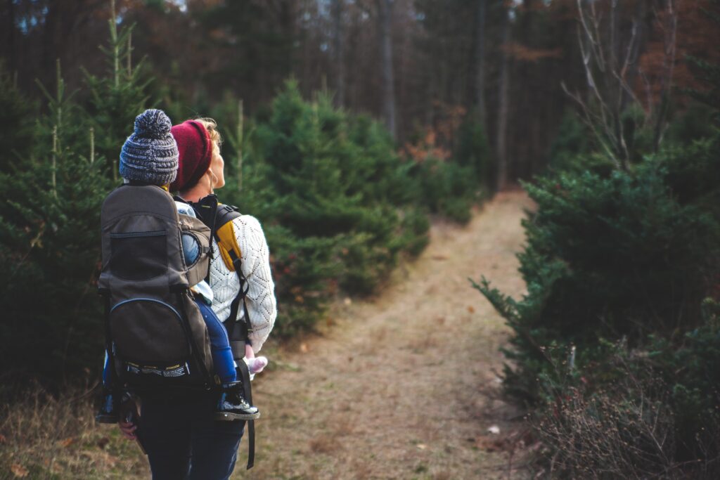 person on trail walking with baby on their back