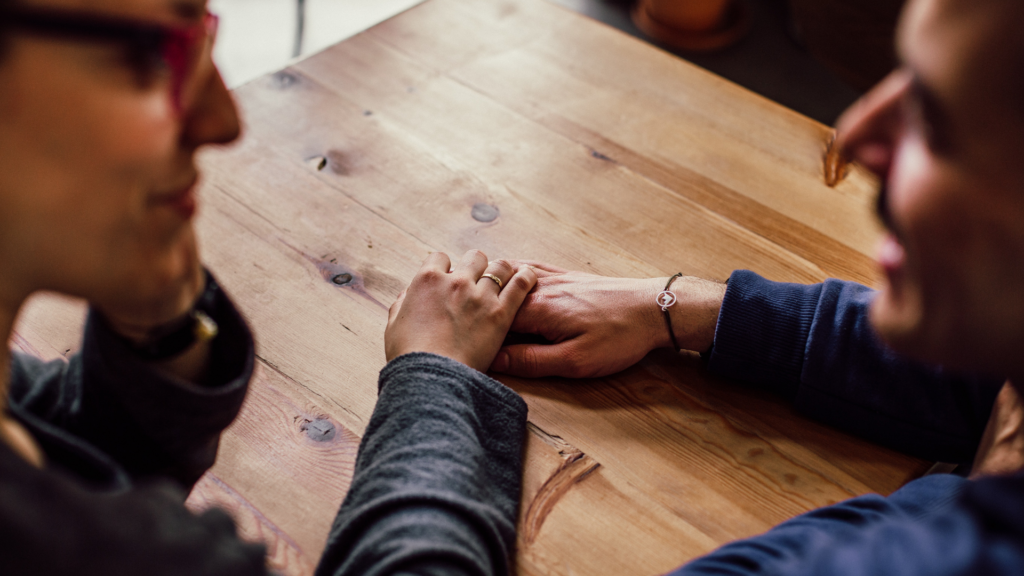 people holding hands looking at each other. Hands are in focus