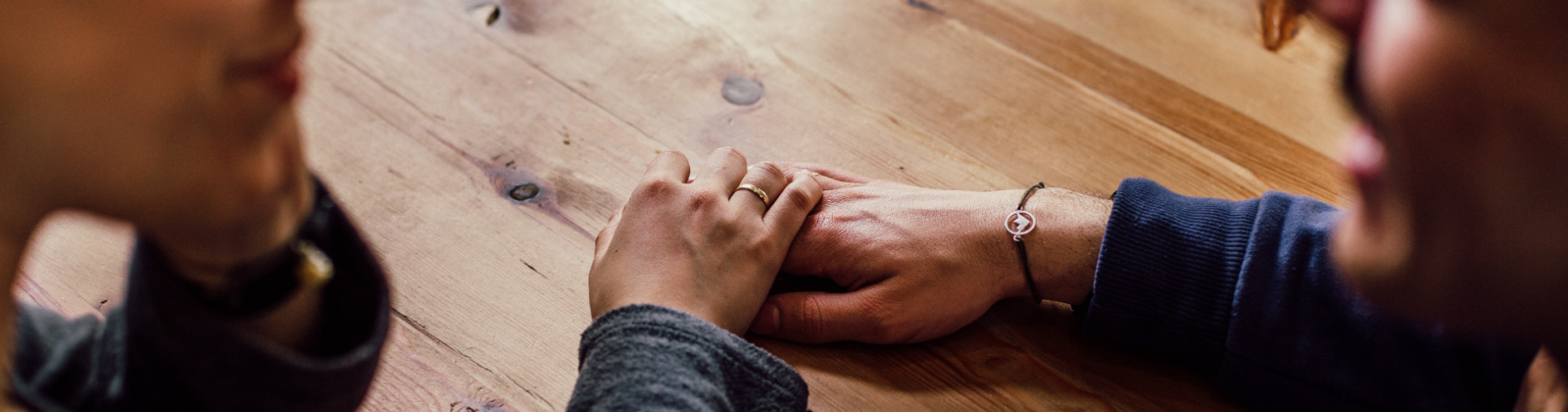 people holding hands looking at each other. Hands are in focus